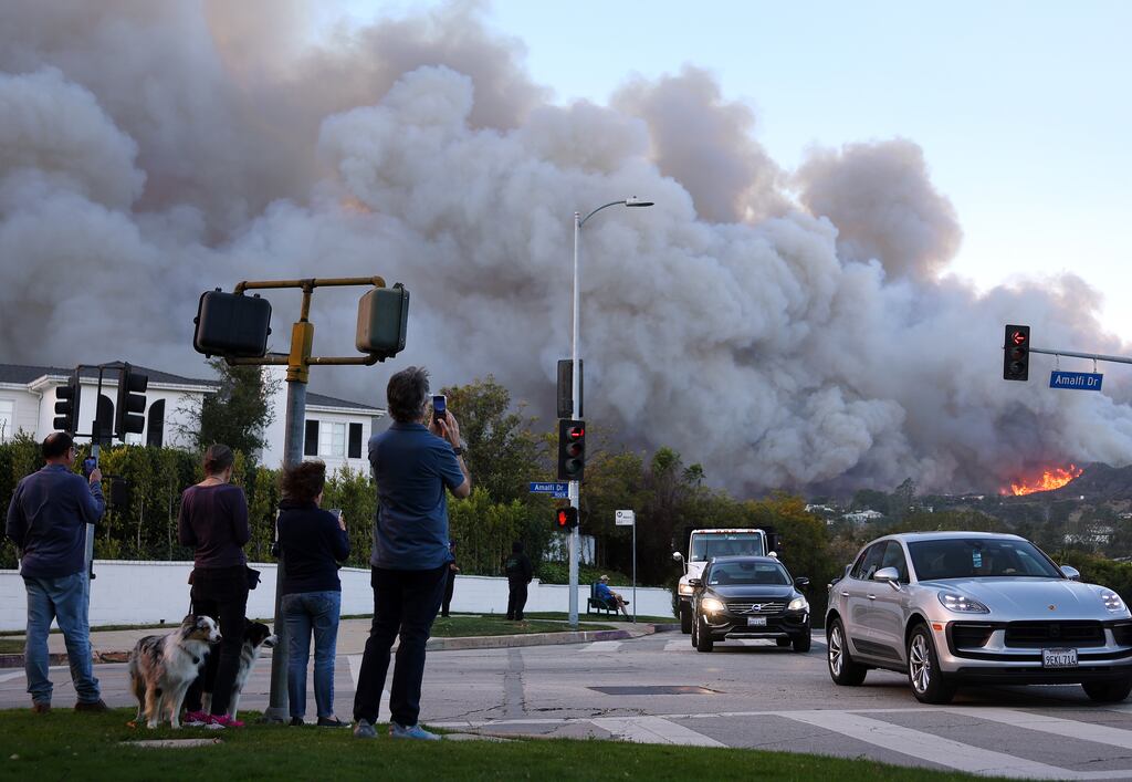 People watch as others drive out of harm's way amid a powerful wildfire and windstorm in Pacific Palisades, California yesterday. Photograph: Mario Tama/Getty Images
