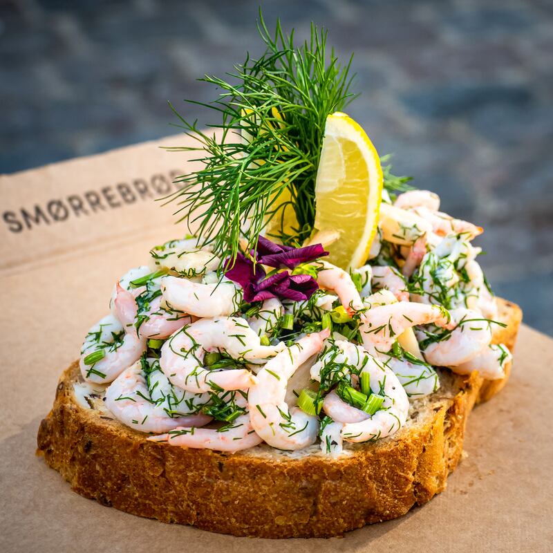 Smørrebrød with prawns, chives, dill, lemon slices and edible flowers. Photograph: Getty