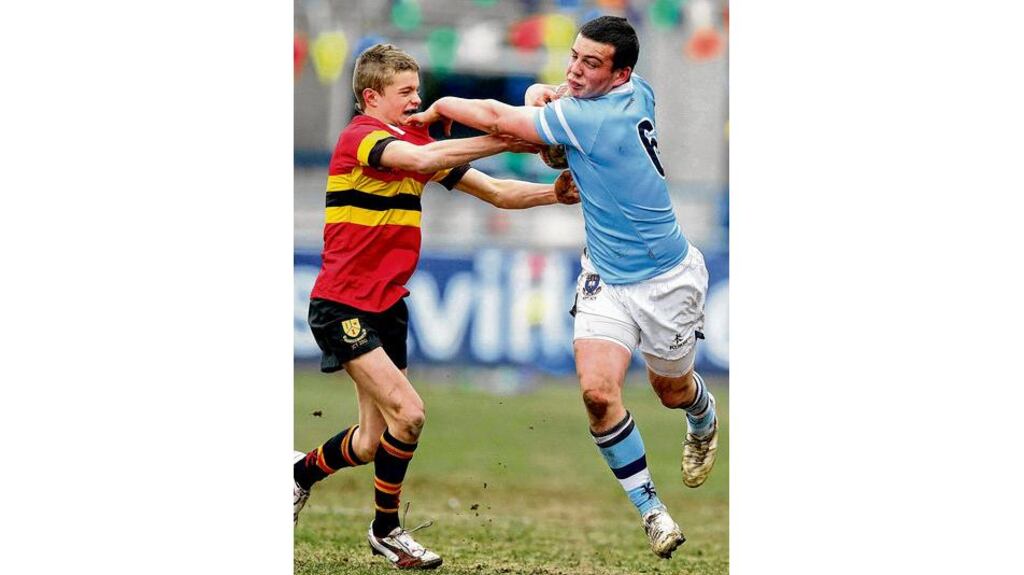 Two-try hero Robert Duffy shrugs off CBC's Robert Jordan in yesterday's Leinster Schools Junior Cup quarter-final at Donnybrook. photograph: morgan treacy/inpho