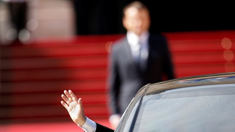 Former French president Francois Hollande waves as president Emmanuel Macron (rear) watches after the handover ceremony at the Elysee Palace in Paris Photograph: Reuters/Yoan Valat/Pool