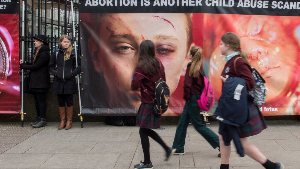 Schoolchildren walk by as anti-abortion activists protest outside the Dáil earlier this month. File photograph: Brenda Fitzsimons/The Irish Times