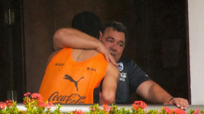 Uruguay’s Luis Suarez is seen embracing a member of the coaching staff on a balcony at the team’s hotel in Natal, after being given a four-month ban from football as well as a nine-match international ban by Fifa. Photograph: Leo Carioca / Reuters