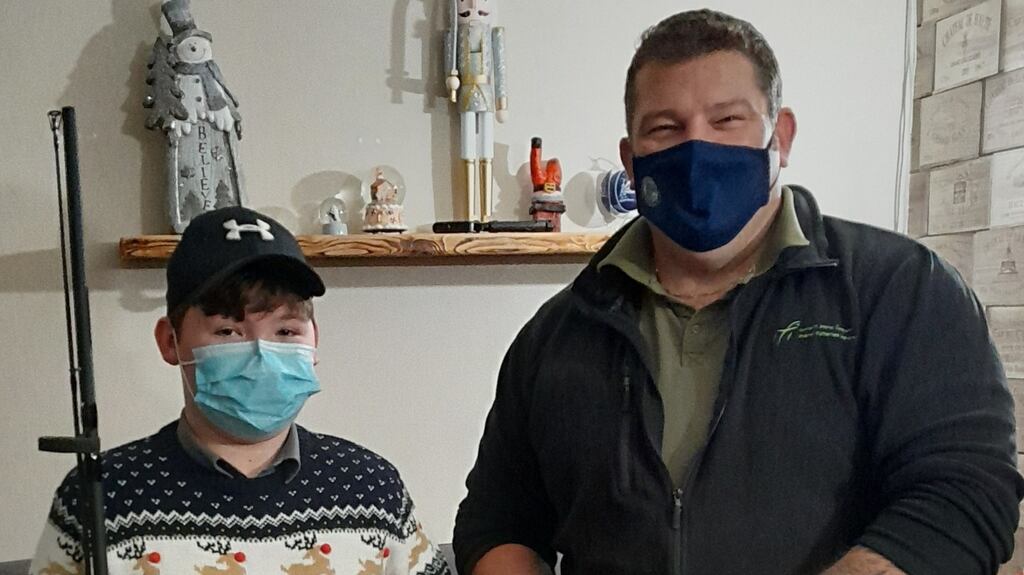 Callum Clark, 12, from Tulsk, Co Roscommon, receiving fishing gear from IFI fisheries officer Andy Burnett following his heroic water rescue of his grandfather at Lake Killina . Callum had lost some of his gear in the accident.