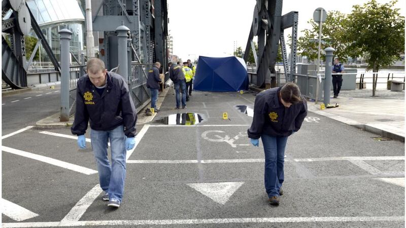 Gardai search the scene of this morning’s fatal crash at North Wall Quay in Dublin city centre. Photograph: Brenda Fitzsimons/The Irish Times