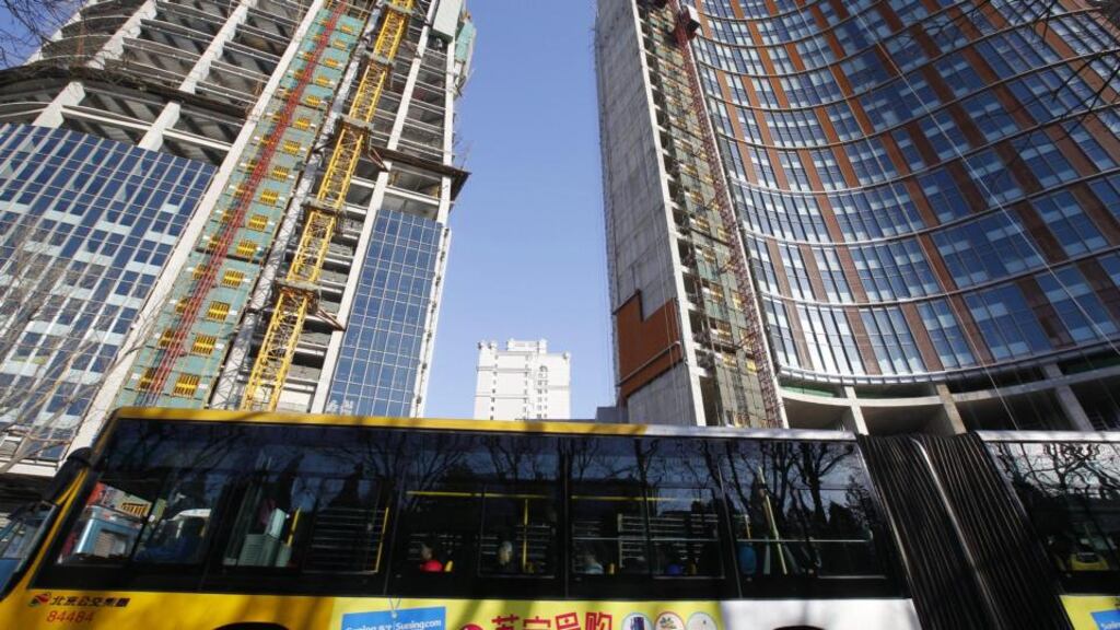 A public bus transporting passengers passes by a building construction site in Beijing, China. Developing countries in Asia will see their benefits of higher demand from recovering advanced economies offset by a slowdown in China’s economy, the Asian Development Bank said. Photograph: Rolex Dela Pena/EPA