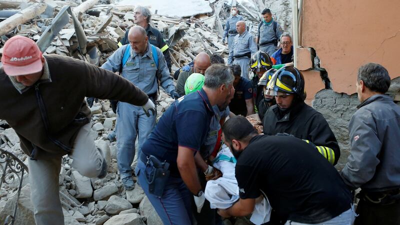 Rescuers carry a person on a stretcher following an earthquake in Amatrice, central Italy. Photograph: Remo Casilli/Reuters