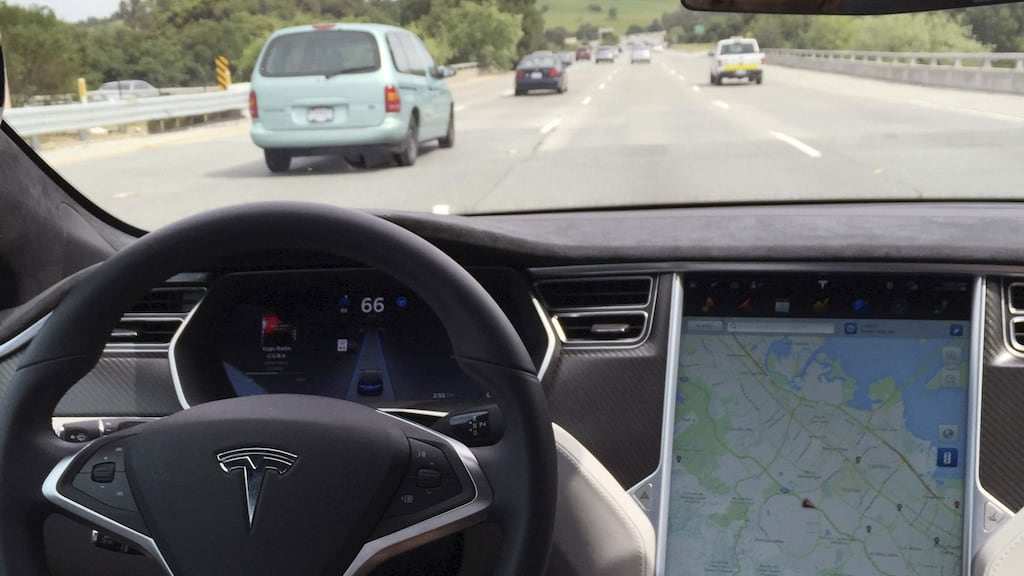 The interior of a Tesla Model S is shown in autopilot mode in San Francisco