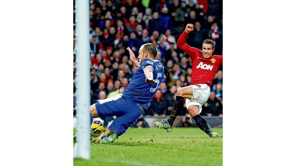 Manchester Uniteds Robin van Persie scores his side's second goal despite the efforts of Everton's John Heitinga at Old Trafford yesterday.