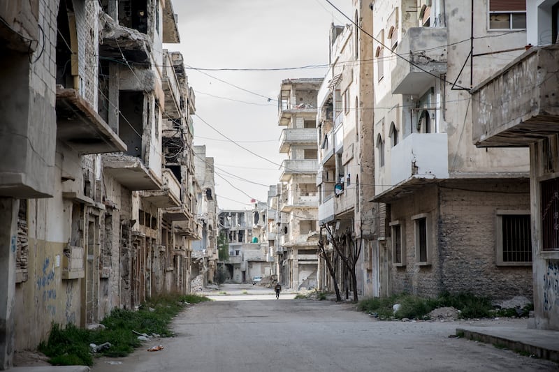 A child runs along the street in a damaged neighbourhood in Homs. Photograph: Sally Hayden