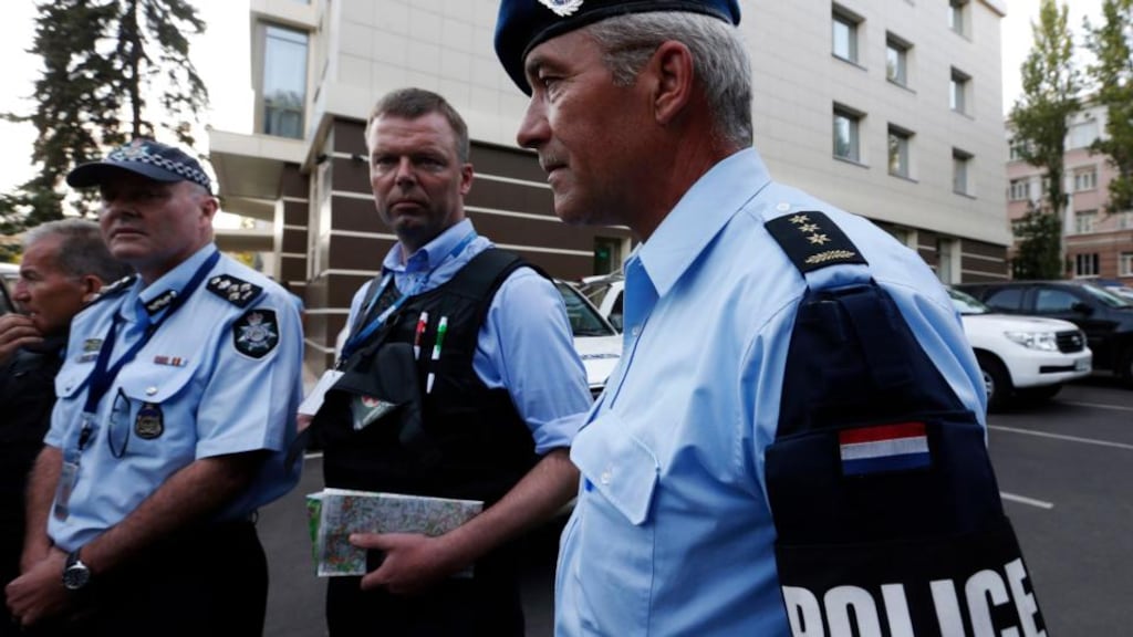 Head of Australian Federal Police mission Commander Brian McDonald (L), Alexander Hug (C), deputy head for the Organisation for Security and Cooperation in Europe’s (OSCE) monitoring mission in Ukraine and Dutch police officer Kuijs arrive back from the site where the downed Malaysian airliner MH17 crashed.