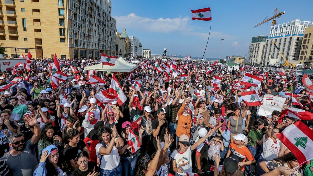 Protesters wave Lebanese flags and shout anti-government slogans in front of the government palace in Beirut, Lebanon. Photograph: EPA/Nabil Mounzer