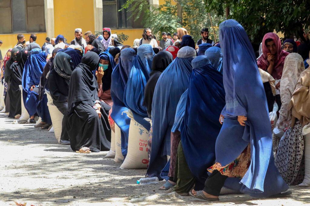 Afghans line up to receive food aid donated by the Chinese government in Kabul, Afghanistan, 17 August 2022. China donated 50 kilogram flour sacks for 1.100 families in need.
