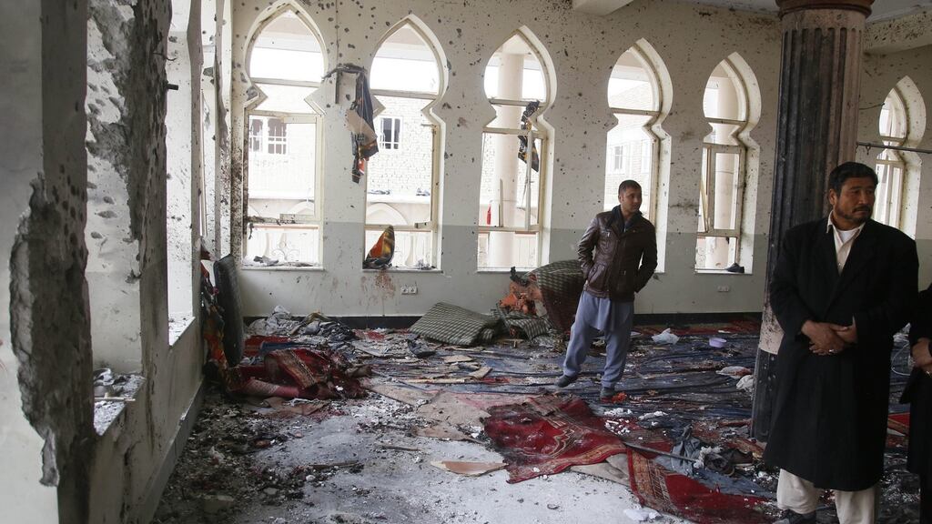 People survey the scene of a suicide bomb attack on a Shia Muslims mosque on Monday. Photograph: Jawad Jalali/EPA