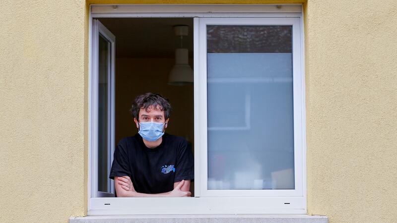 Jonathan Peterschmitt poses at his window during his home quarantine in Bernwiller, near Mulhouse, France. Photograph: Denis Balibouse/Reuters