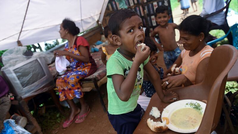 A Sri Lankan boy affected by torrential floods eats a meal at a road camp in the Kelaniya suburb of Colombo on Wednesday. Photograph: AFP/Getty Images