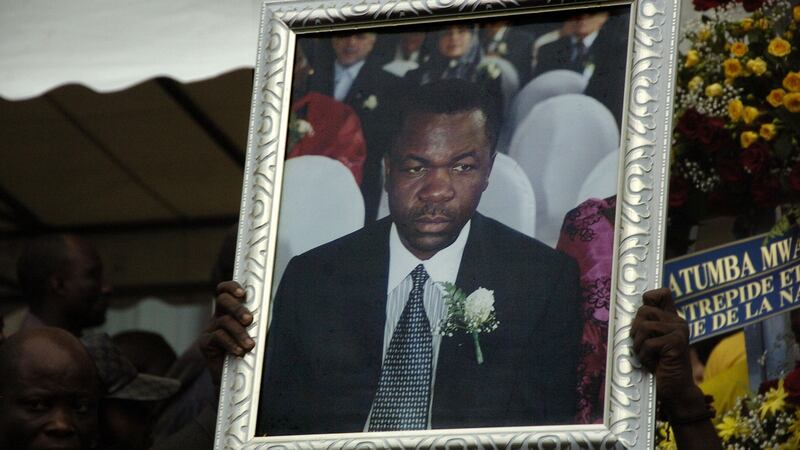 A man holds up a photograph of Augustin Katumba Mwanke, a close aide of President Joseph Kabila, who was killed in a plane crash on February 12th, 2012, during a ceremony at the People Palace in Lingwala, Democratic Republic of Congo. File photograph: Junior D Kannah/AFP/Getty Images