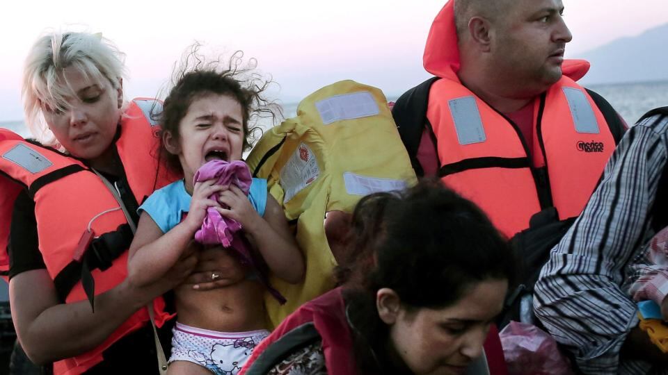 Migrants get out of an inflatable boat as they arrive on Kos. Photograph: Angelor Tzortzinis/AFP/Getty Images