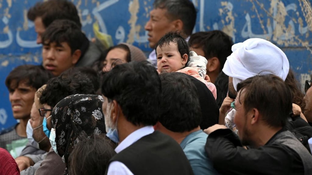Afghans gather on a roadside near the military part of the airport in Kabul on Friday. Photograph: Wakil Kohsar/AFP via Getty Images