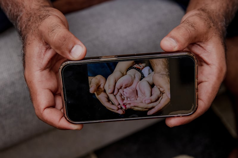 Majid Khan shows a photograph of his family’s hands holding the hand of their newborn son, Hamza. Photograph: Natalie Keyssar/New York Times