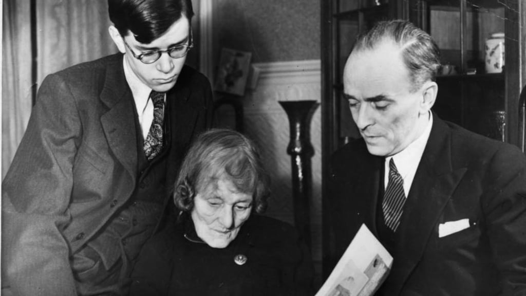 Maud Gonne MacBride with her son Sean MacBride (right) and grandson Tiernan look over ‘an album of photos of Troubled Times in Ireland’