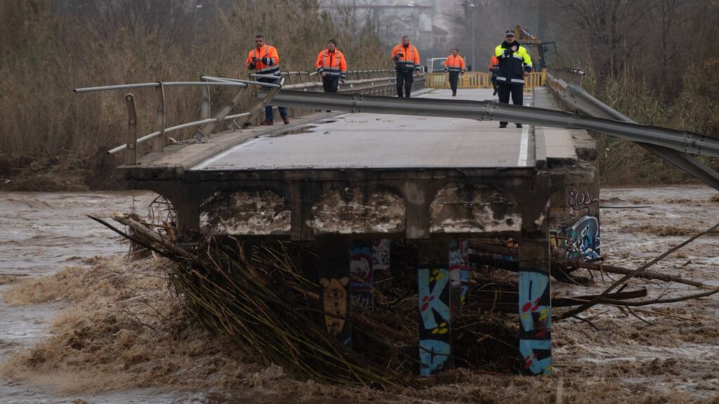 Policemen and security personnel walk on a fallen bridge in Malgrat de Mar, near Girona, Spain. Photograph: Josep Lago/AFP via Getty Images
