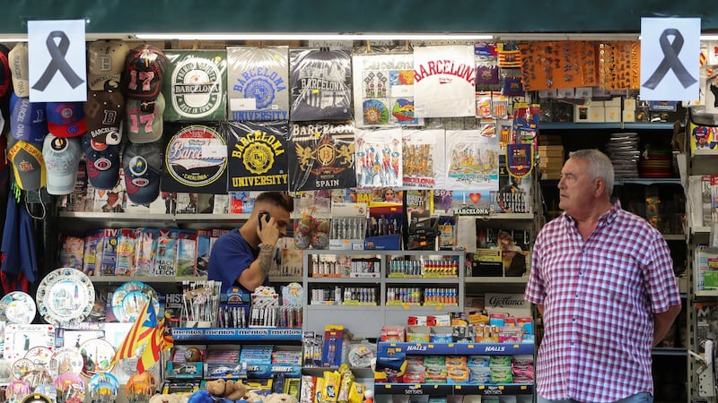 Placards with black ribbons hang on a kiosk in the area where a van crashed into pedestrians at Las Ramblas. Photograph: Sergio Perez/Reuters