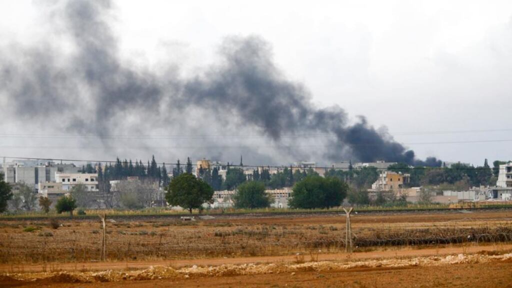 Smoke rises from the Syrian town of Kobani, seen from the Mursitpinar border crossing on the Turkish-Syrian border in the southeastern town of Suruc in Sanliurfa province yesterday. The United States is bombing targets in Kobani for humanitarian purposes to relieve defenders of the Syrian town and give them time to organize against Islamic State militants. Photograph: Reuters