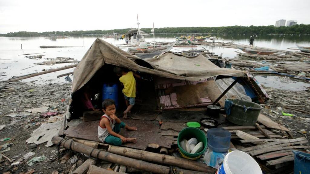 Filipino children outside their makeshift home while waiting for evacuation at a coastal area in Paranaque city, south of Manila, Philippines, in 2014. Photograph: Ritchie Tongo/EPA