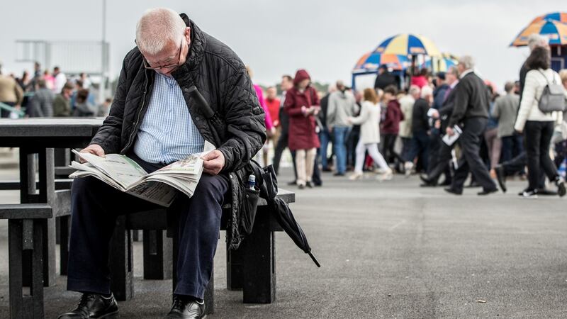 A punter reads in on the second day of the Galway Racing Festival at Ballybrit. Photograph: James Crombie/Inpho