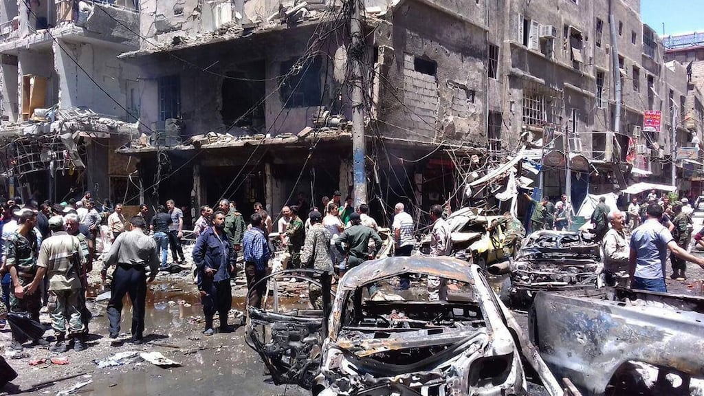 Syrians gather around damaged buildings after a bombing attack at the Sayyida Zeinab suburb, Damascus on Saturday. Photograph: SANA/AP
