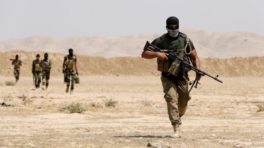 Asaib Ahl al-Haq Shia militia fighters from the south of Iraq and Kurdish peshmerga forces walk with their weapons as they take control of Sulaiman Pek from the Islamist State militants, in the northwest of Tikrit city today. Photograph: Youssef Boudlal/Reuters