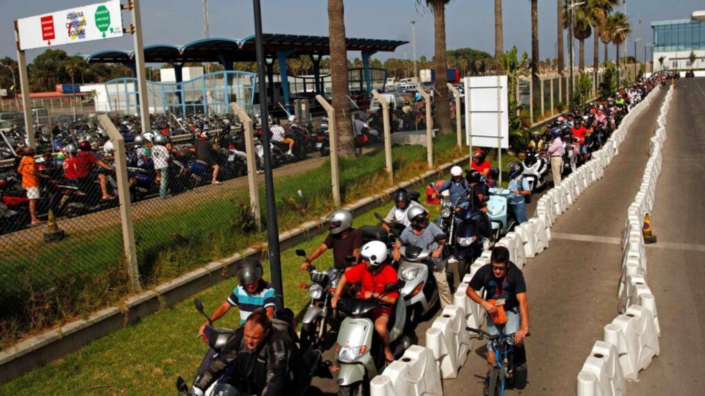 Workers wait in line with their motorcycles and scooters to enter Spain (left) at its border with the British territory of Gibraltar. Photograph: Jon Nazca/Reuters