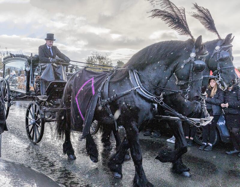 Two black horses draw the carriage taking the remains of Thomas Gallagher to St Mary's Church, Ballybrack