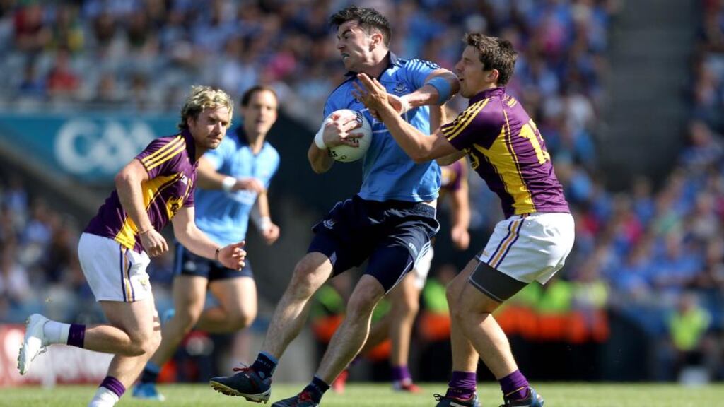 Dublin’s Michael Darragh Macauley and Ciaran Lyng of Wexford in a close-quarter struggle during the Leinster senior football championship semi-final in Croke Park on Sunday. Photograph: Inpho