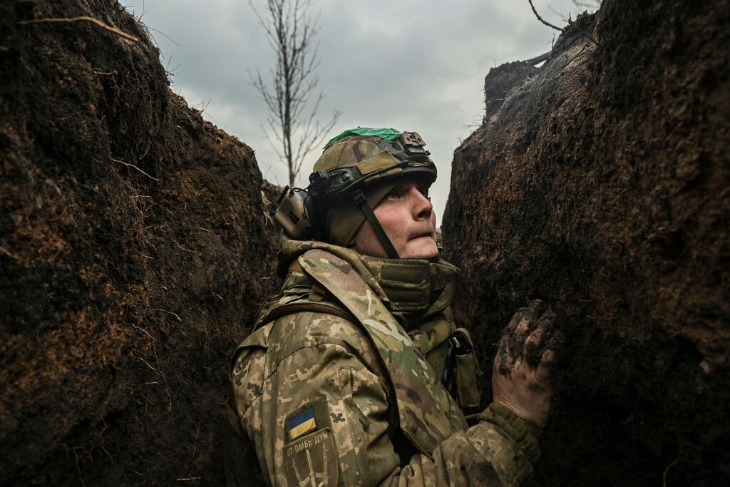 A Ukrainian serviceman taking cover in a trench during shelling near the city of Bakhmut on Wednesday. Photograph: Aris Messinis /AFP via Getty Images