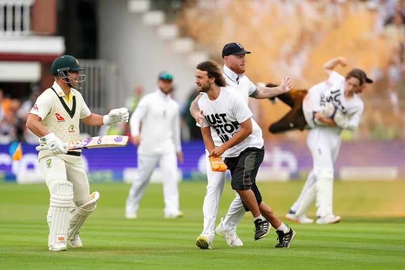 England's Ben Stokes (centre) grabs a Just Stop Oil protestor whilst Johnny Bairstow (right) carries another protester off the field. Photograph: Mike Egerton/PA Wire