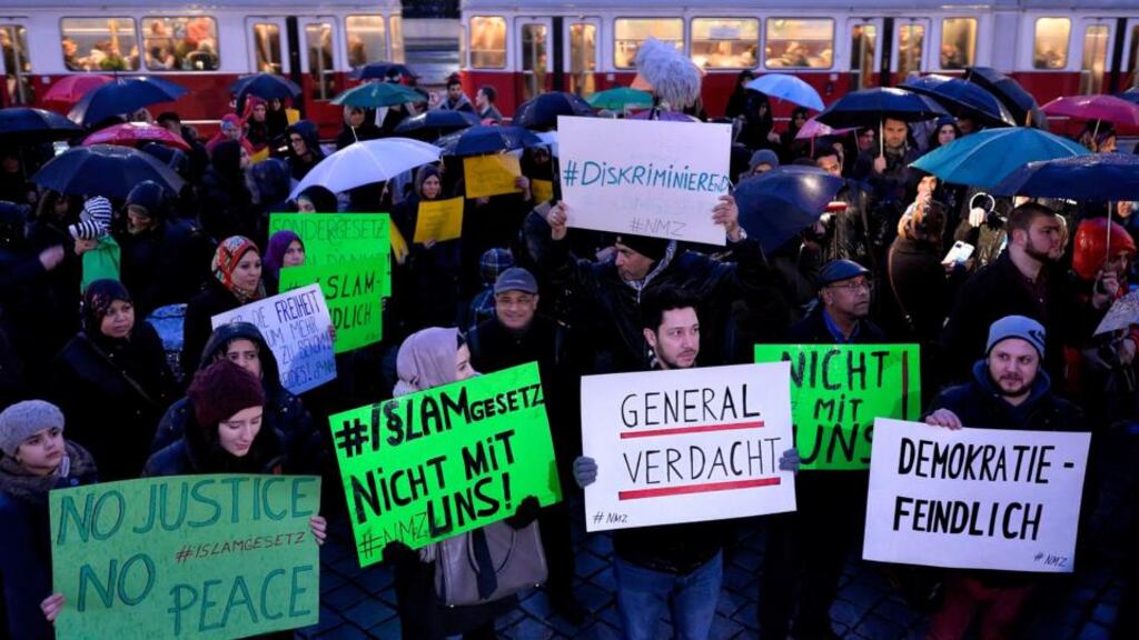 Protesters hold banners during the demonstration under the slogan ‘New Islam Law? Not with us!’ in front of the parliament ahead of the vote. Photograph: Herbert Neubauer/EPA
