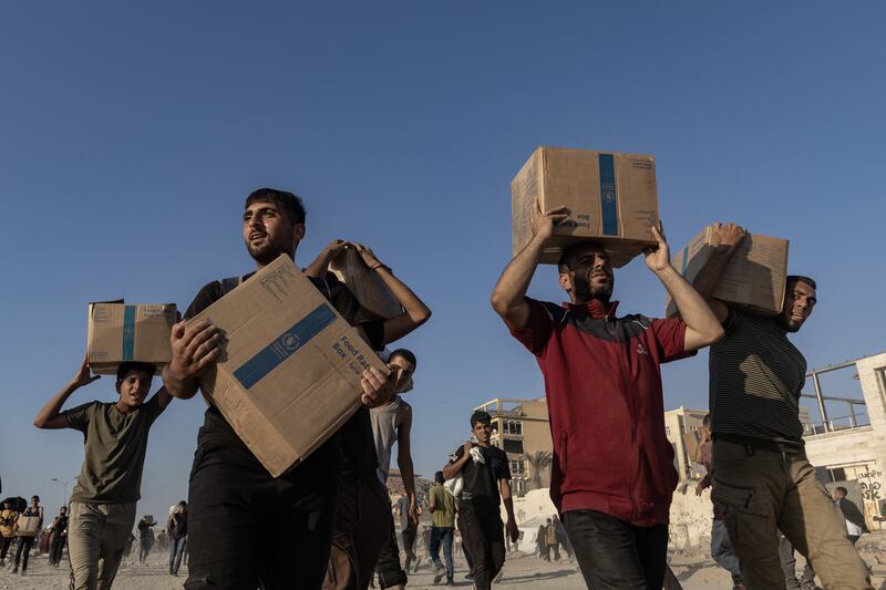Palestinians carry parcels of donated food while others hurry towards a distribution point northwest of Gaza City. Photograph: Saher Alghorra/The New York Times