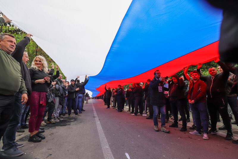 People hold a giant Serbian flag during a protest in front of the city hall in the town of Zvecan. Photograph: Bojan Slavkovic/AP