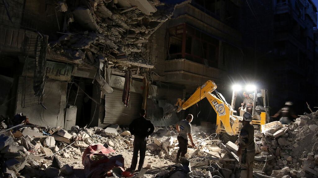 Civil Defense members search for survivors at a site hit by an air strike in the rebel-held al-Shaar neighbourhood of Aleppo, Syria. Photograph: Abdalrhman Ismail/Reuters