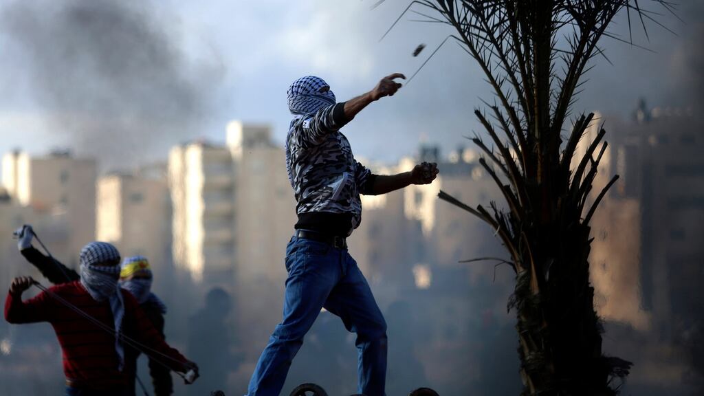 Palestinian protesters throw stones during clashes with Israeli soldiers following a protest in the west Bank city Ramallah. Photograph: Shadi Hatem/EPA