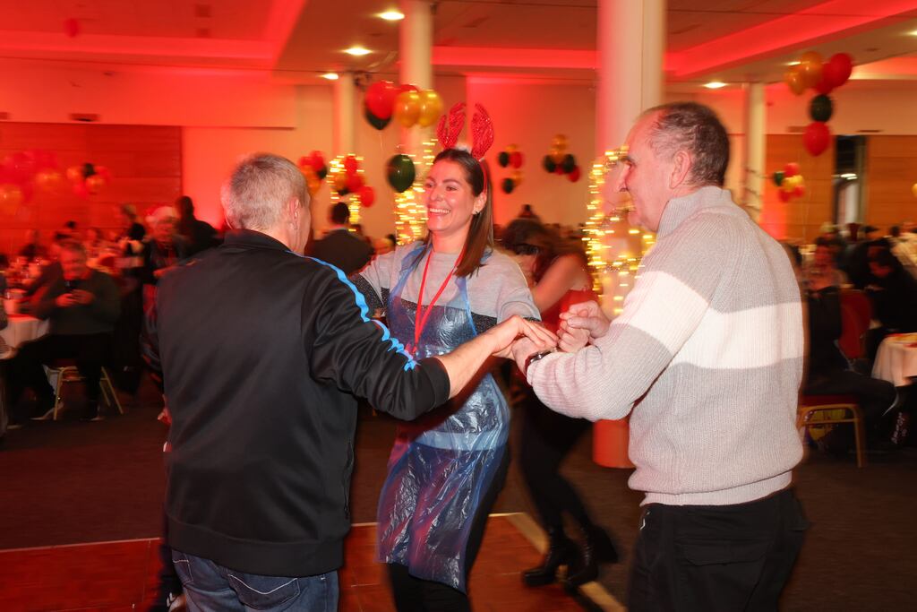 Volunteer Fernanda Power dancing with guests at the Knights of St Columbanus Christmas Day dinner at the RDS, Dublin. Photograph: Dara Mac Dónaill