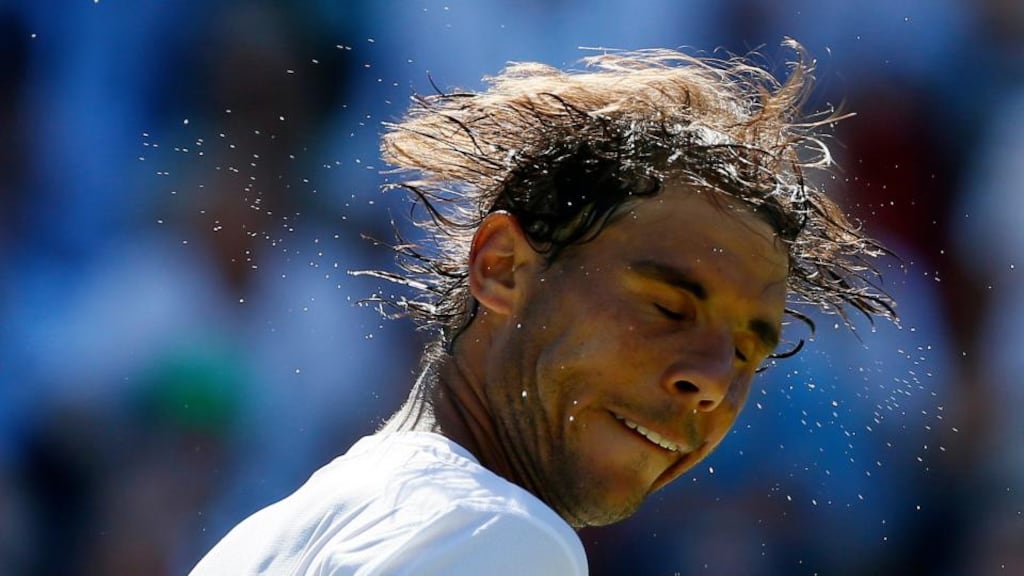 Rafael Nadal of Spain shakes sweat of his head after winning his match against Brazil’s Thomaz Bellucci at Wimbledon. Photograph: Stefan Wermuth/Reuters