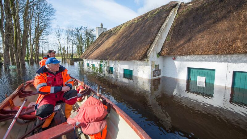 James and Jimmy Curley from Gort passing the recently resotred cottages at Thoor Ballylee in Gort. Photograph John Mangan