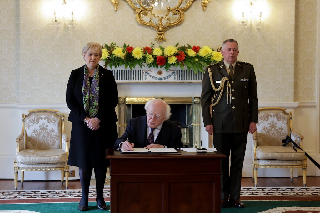 President Michael D Higgins signs posthumous presidential pardons for Sylvester Poff and James Barrett at a ceremony in Áras an Uachtarain. Photograph: Maxwells