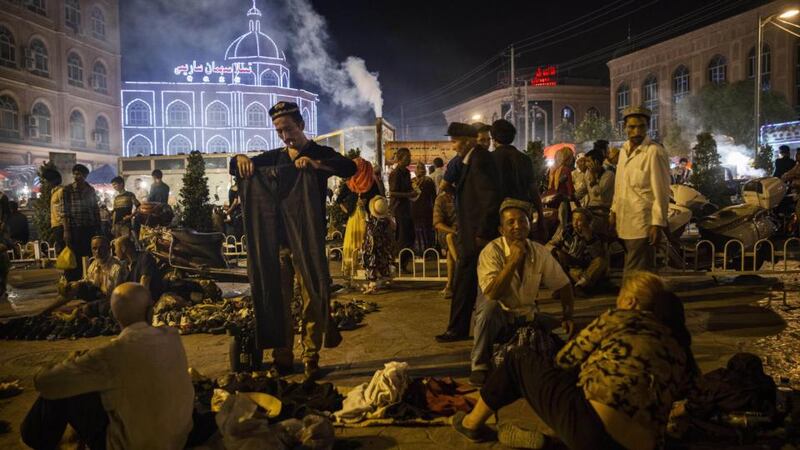 A Uighur man looks at pants for sale before the Eid holiday at a night market on July 28th, in old Kashgar, Xinjiang province, China. Photograph: Kevin Frayer/Getty Images