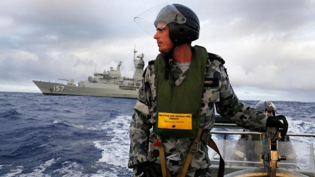 Standing in a rigid hull inflatable boat launched from the Australian Navy ship HMAS Perth, leading seaman, boatswain’s mate, William Sharkey searches for possible debris in the southern Indian Ocean in the continuing search for the missing Malaysian Airlines flight MH370. Photograph: Australian Defence Force/Handout via Reuters