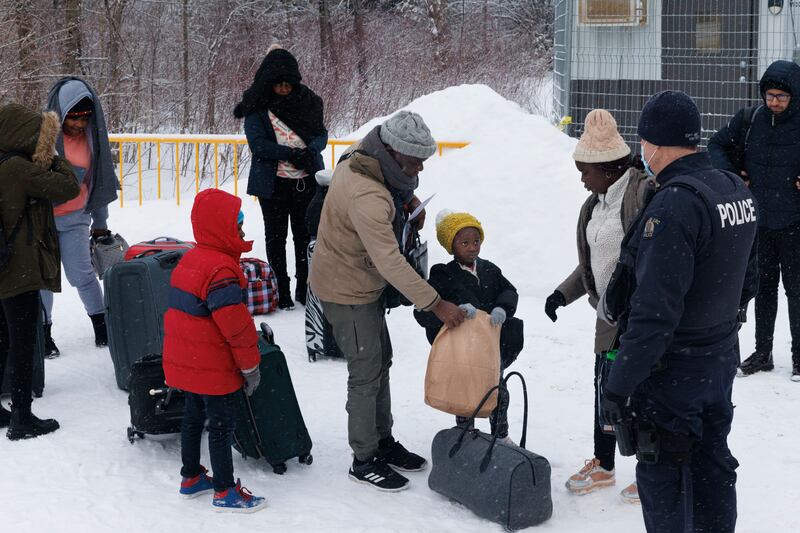 An Angolan family explaining to their young daughter that she can eat once she's let inside the processing facility at the Roxham Road border crossing in Saint-Bernard-de-Lacolle, Quebec. Photograph: Nasuna Stuart-Ulin/New York Times