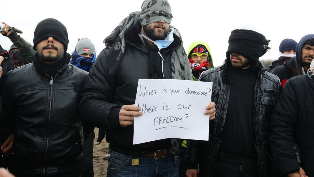 Migrants and refugees stage a protest as demolition continues at the Calais migrant camp, known as the “Jungle”, in northern France. Photograph: Gareth Fuller/PA Wire