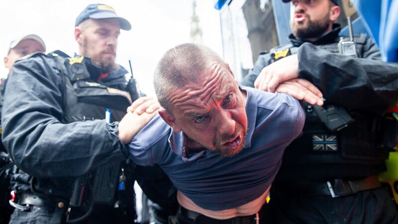 A men  is detained by police after scuffles broke out   following the sentencing of Tommy Robinson in London. Photograph:  Luke Dray/Getty Images